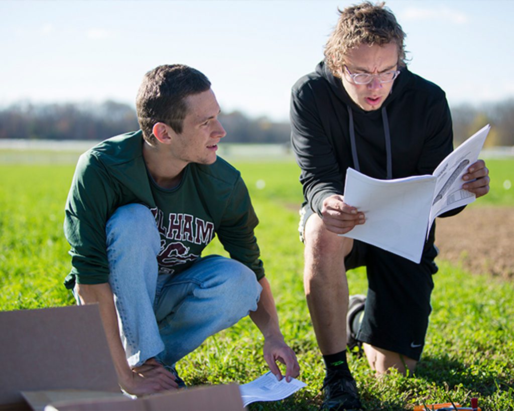 Two Earlham students discussing sustainability in the field