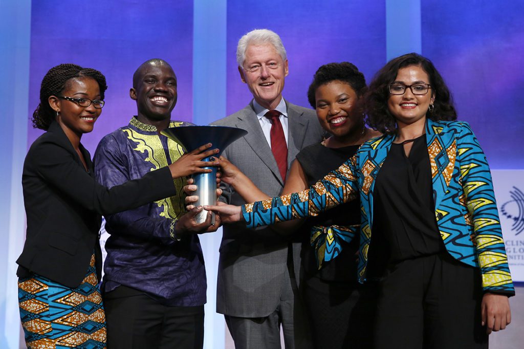 Former US President Bill Clinton (center) stands with Winners, Leslie Ossete, Wyclife Omondi, Iman Cooper and Sonia Kabra of Team Magic Bus, from Earldom College, winner of the Hult Prize during the Hult Prize Finals and Awards Dinner 2016 at the Clinton Global Initiative Annual Meeting on Tuesday, Sept. 20, 2016, in New York. (Brian Ach/AP Images for Hult Prize Foundation)