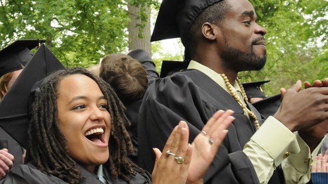 two smiling and cheering graduates