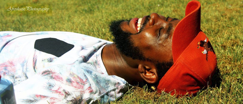 African american male in hat laughing on ground