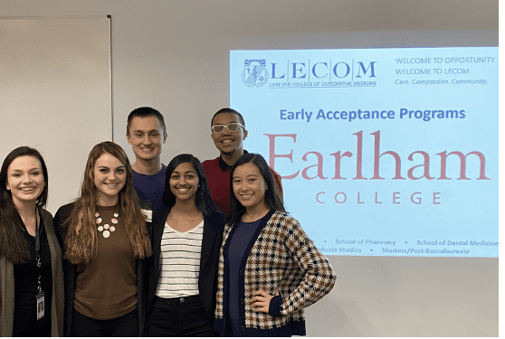 LECOM recipients standing in front of a projected screen in a classroom