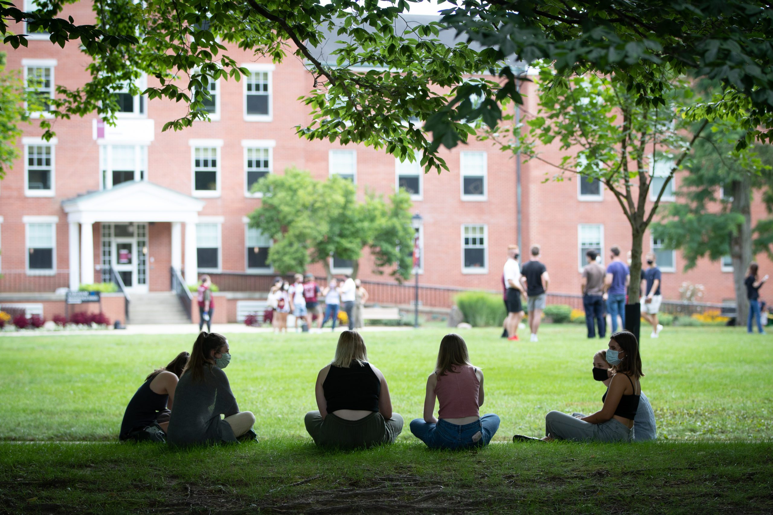 A group of four students sitting in the lawn of the Heart at Earlham College.