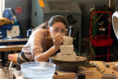 Student intensely working on a metalsmithing piece