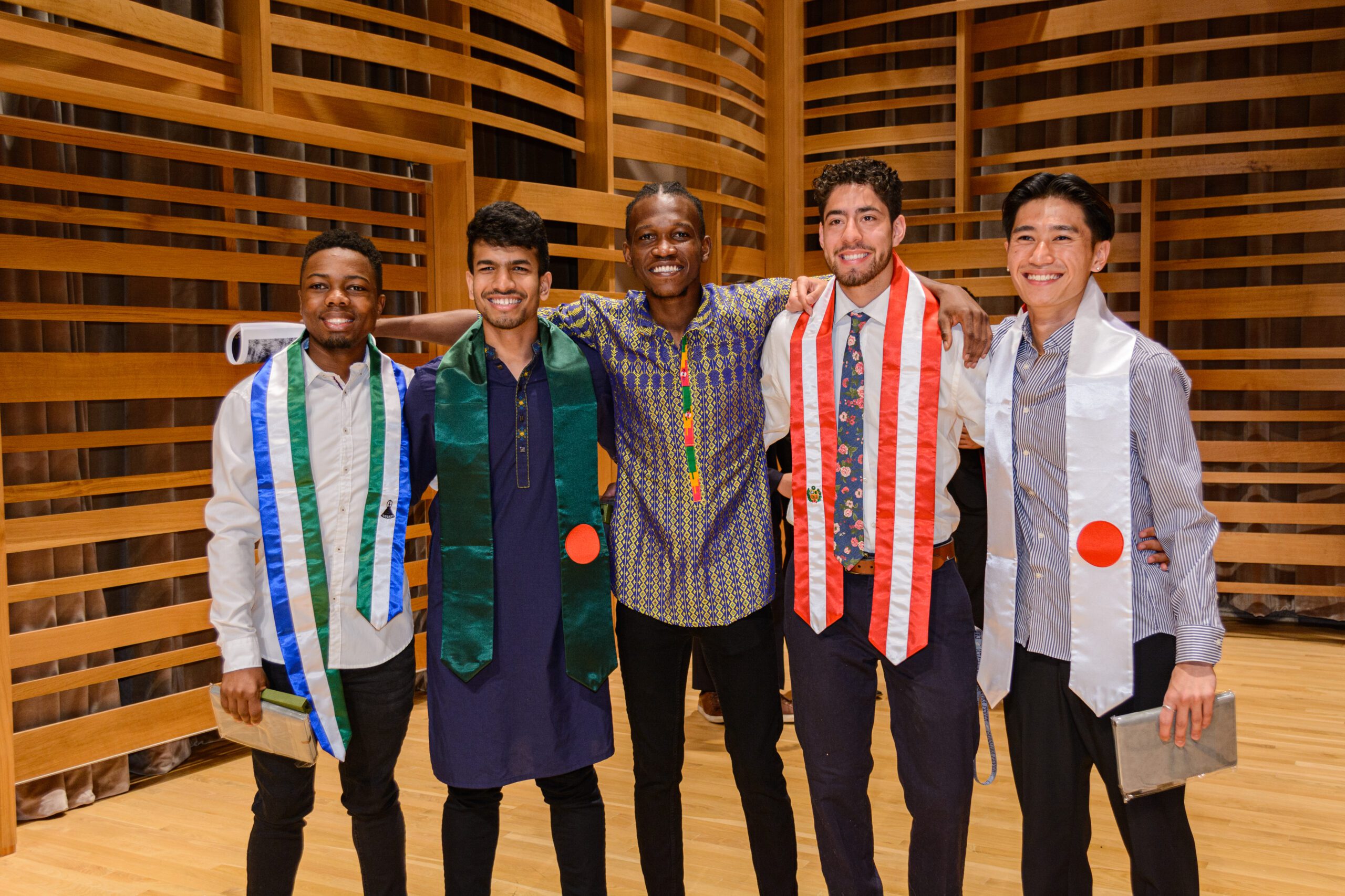 Students from different countries pose for a photograph during multicultural graduation.