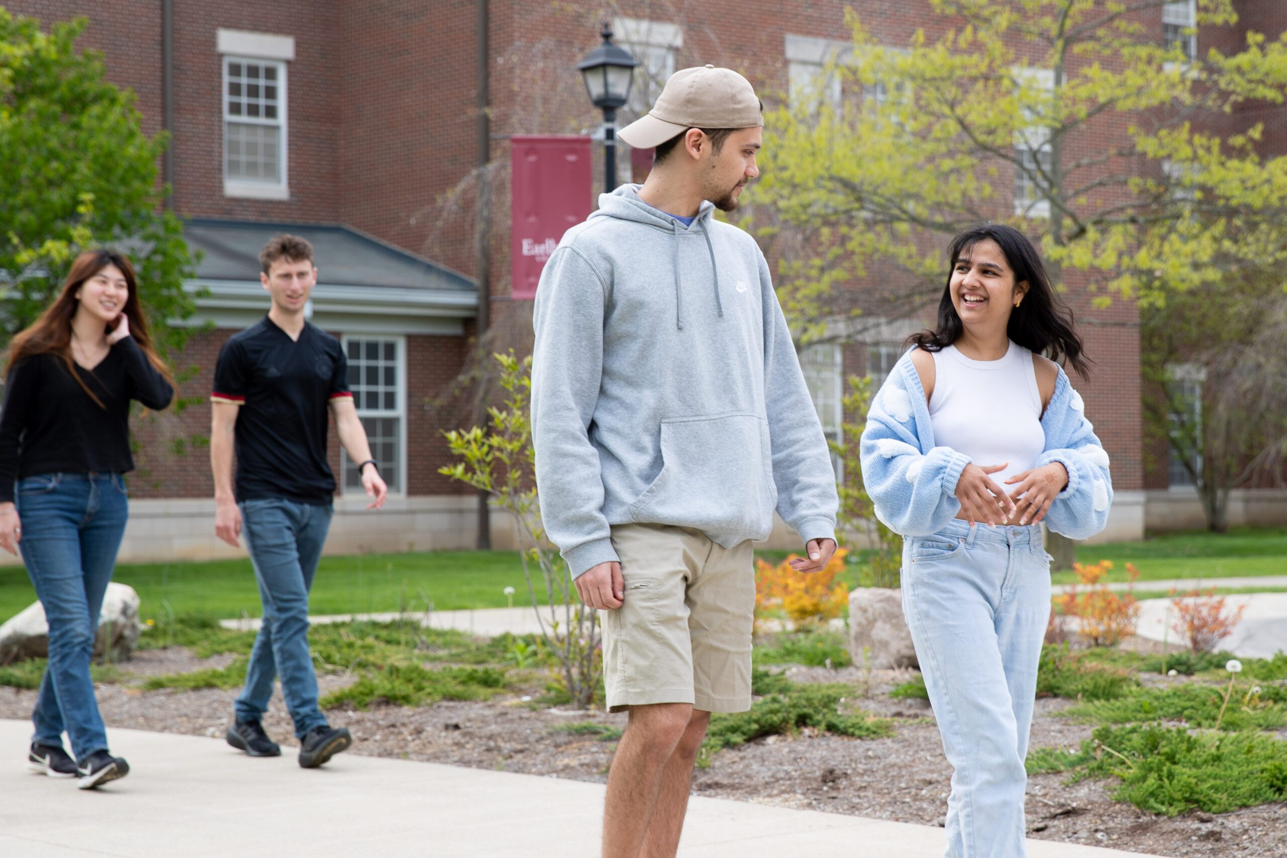Students walking and smiling as they walk between campus buildings