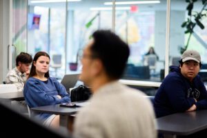 Professor Peng Yu sits in the foreground of one of his politics classes surrounded by other students.
