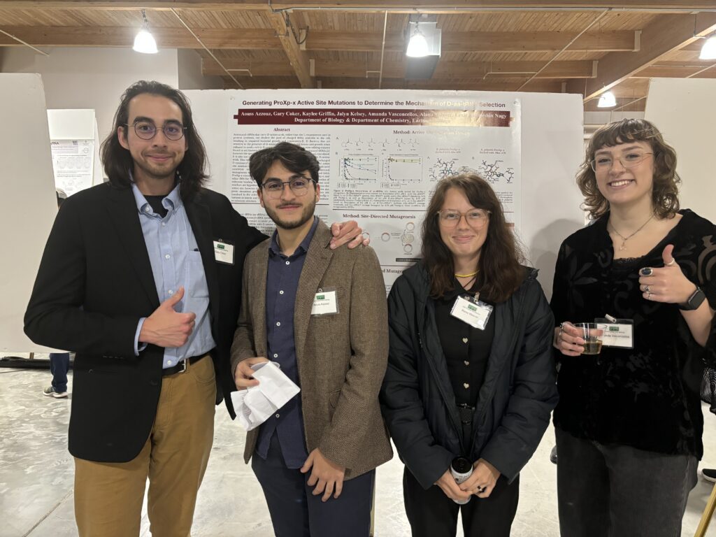 Four Earlham students, two masculine students and two feminine students dressed in business casual, pose for a group photo