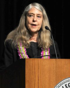 Margaret Hamilton stands behind a podium on the Goddard Auditorium stage during Earlham College's Outstanding Alumni Award ceremony.