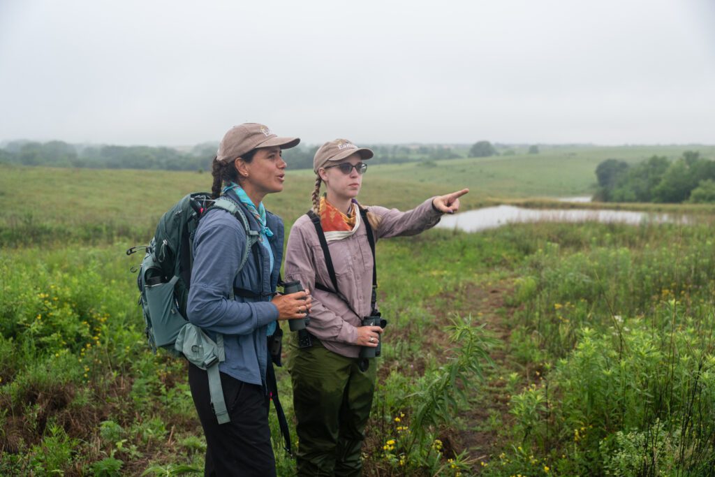 Earlham College professors Wendy Tori and Jaime Coon look out across the grasslands of Iowa during a field research experience.