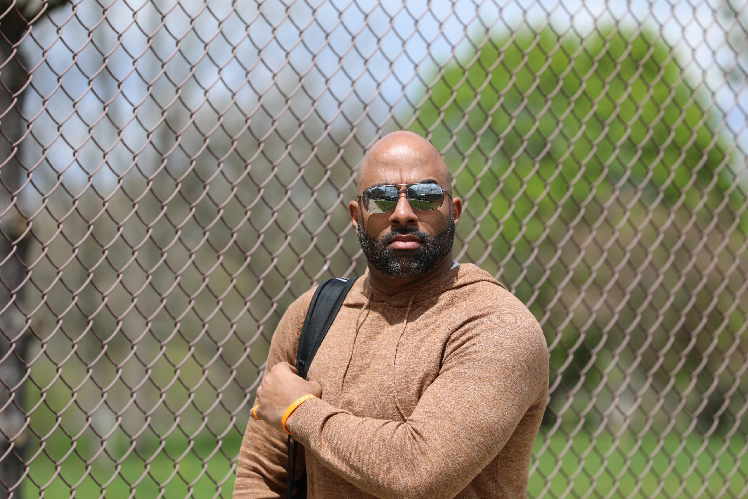 Nick Johnson stands in front of a chain link fence outside a baseball stadium