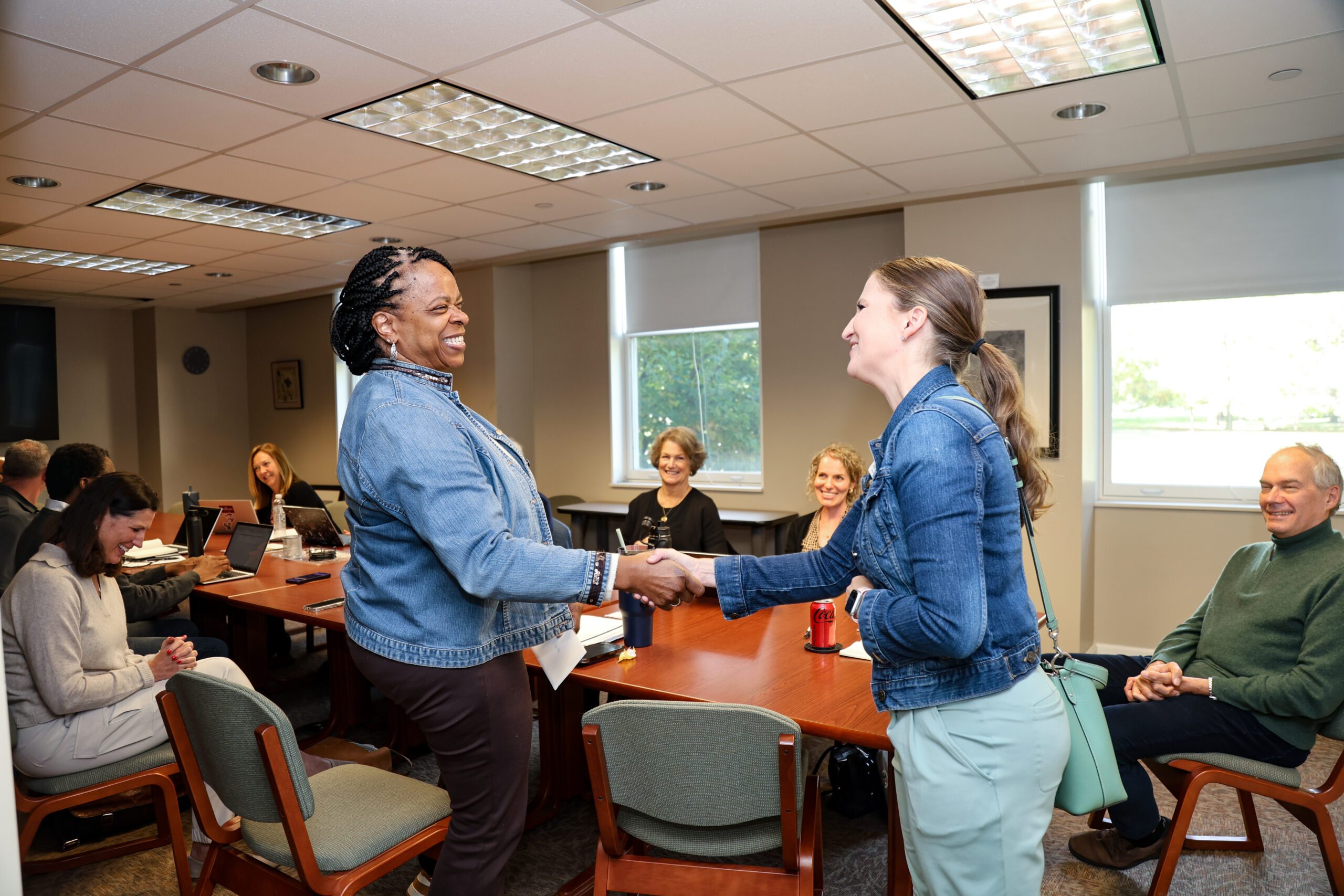 Bonita Washington-Lacey is pictured left shaking hands with Lynette Davis of the Wayne County Area Chamber of Commerce after a surprise announcement in a conference room about the Educator of the Year Award.