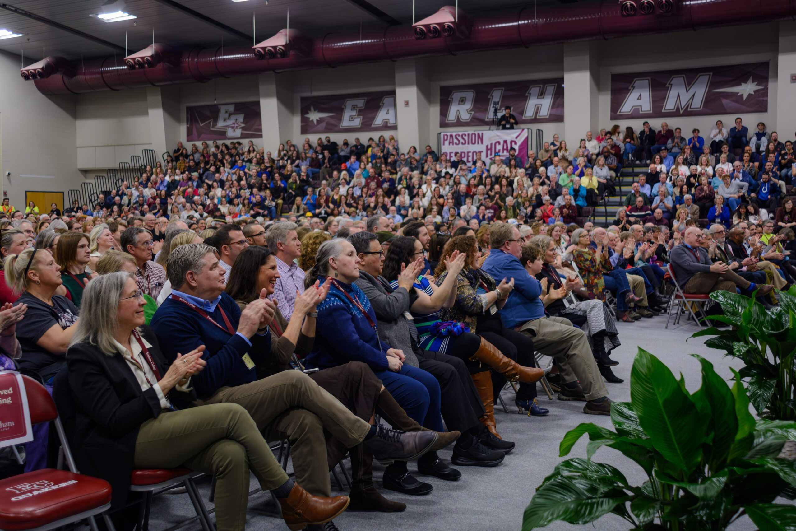 Hundreds of people clap while seated in Druley Performance Gym
