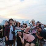A group of students pose with a skyline in the background
