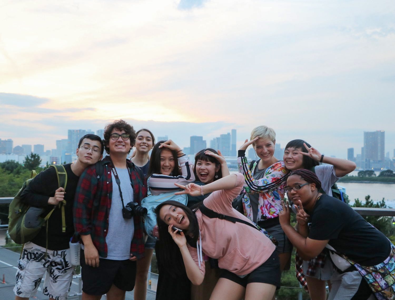 A group of students pose with a skyline in the background