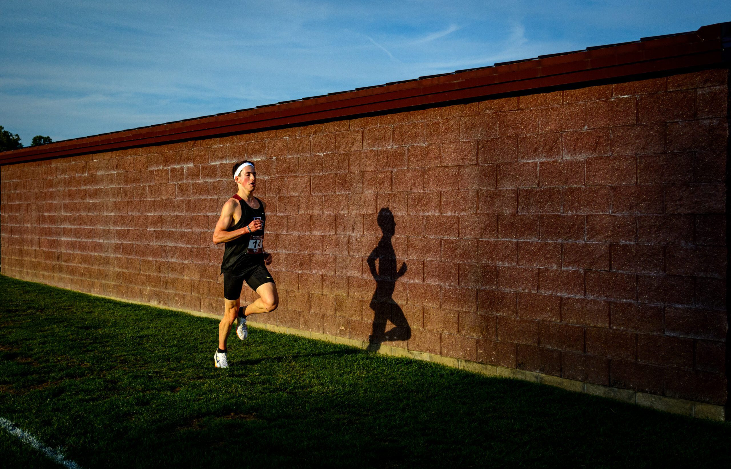Ethan Rose running alongside a brick wall